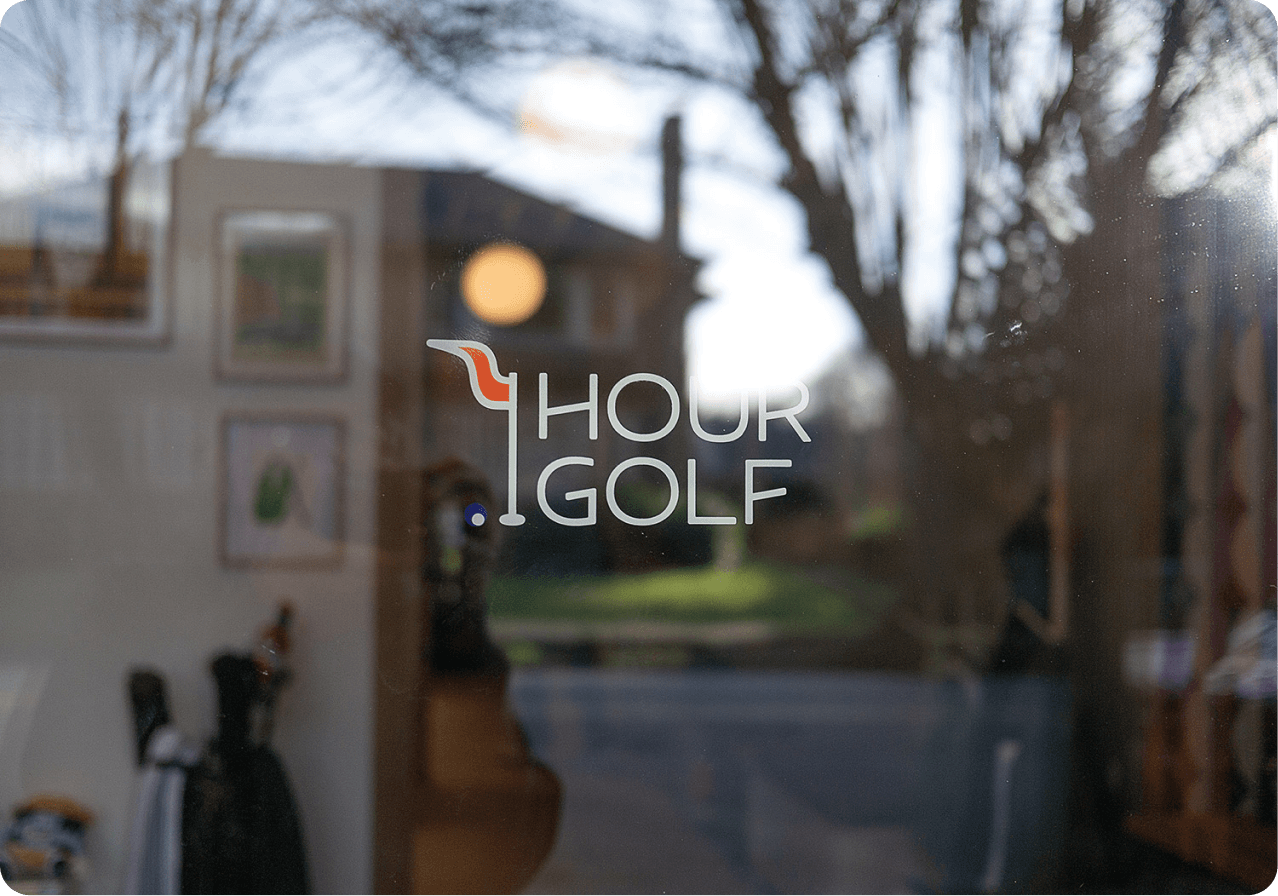 Hour Golf storefront window with the Hour Golf logo etched in the glass