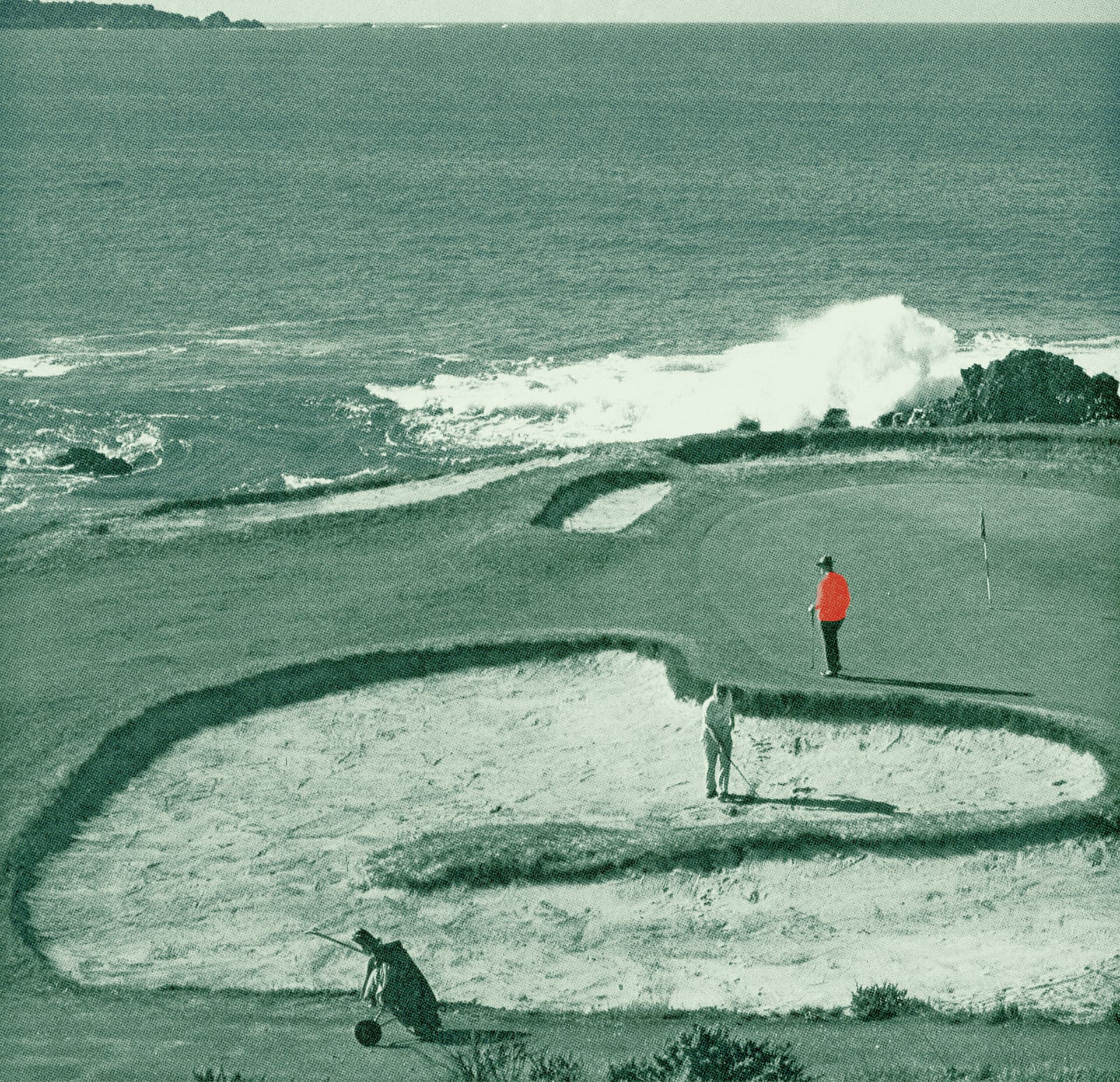 Duotone green photo of a coastal golf course with crashing waves, a player in a red shirt on the green, and another walking through the sand
